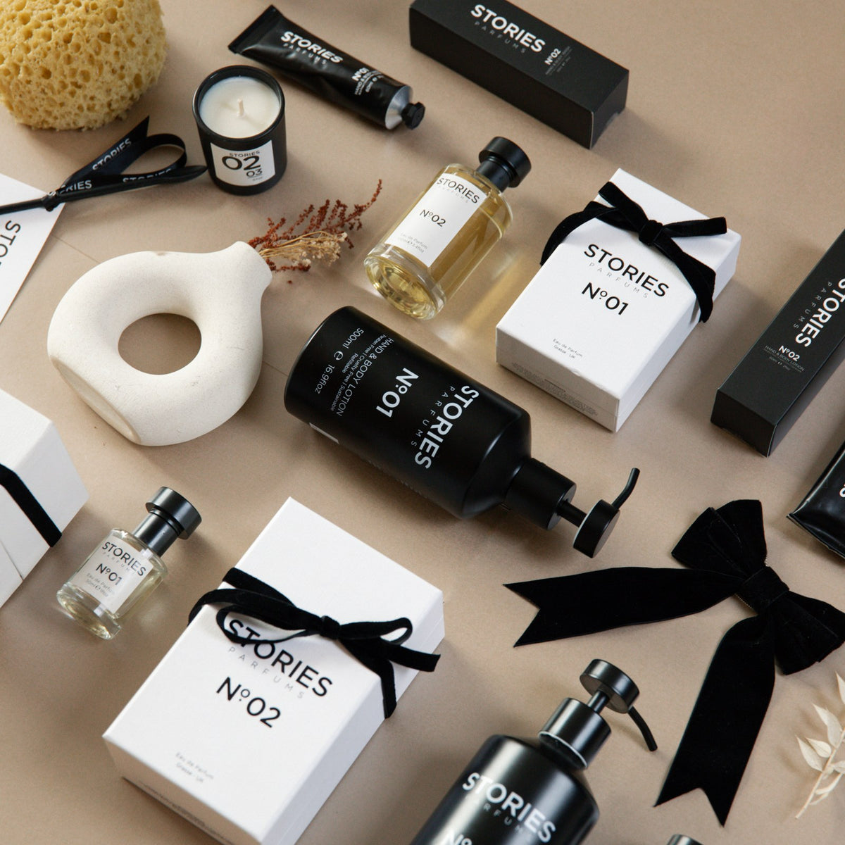 STORIES Nº.02 Christmas flat lay with Eau de Parfum box tied in black velvet ribbon and Hand & Body