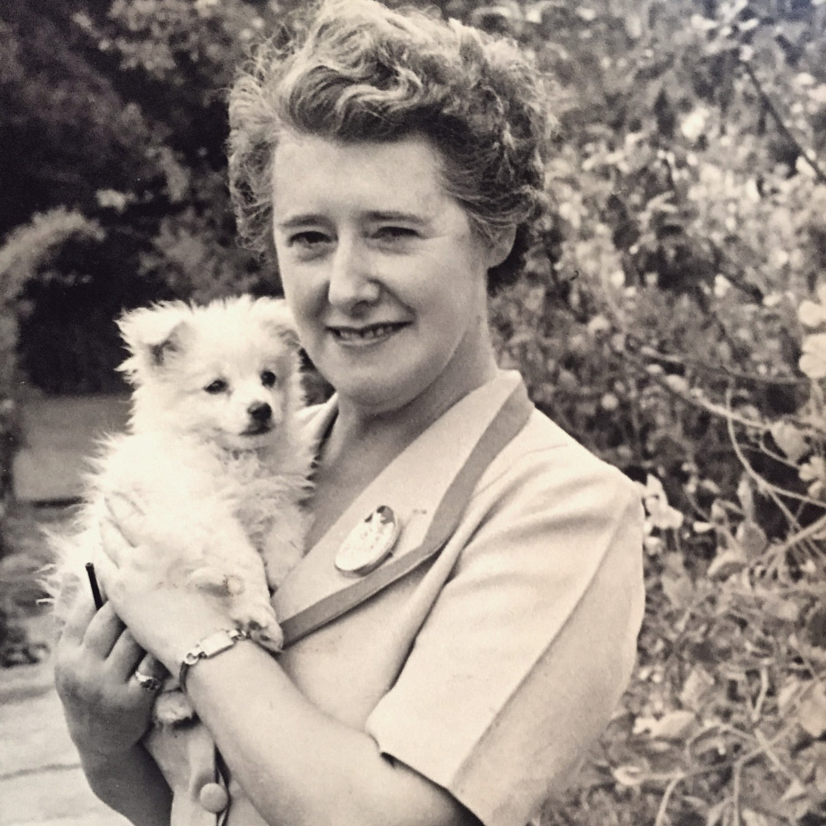 Tonya's grandmother in her garden, holding a small white dog