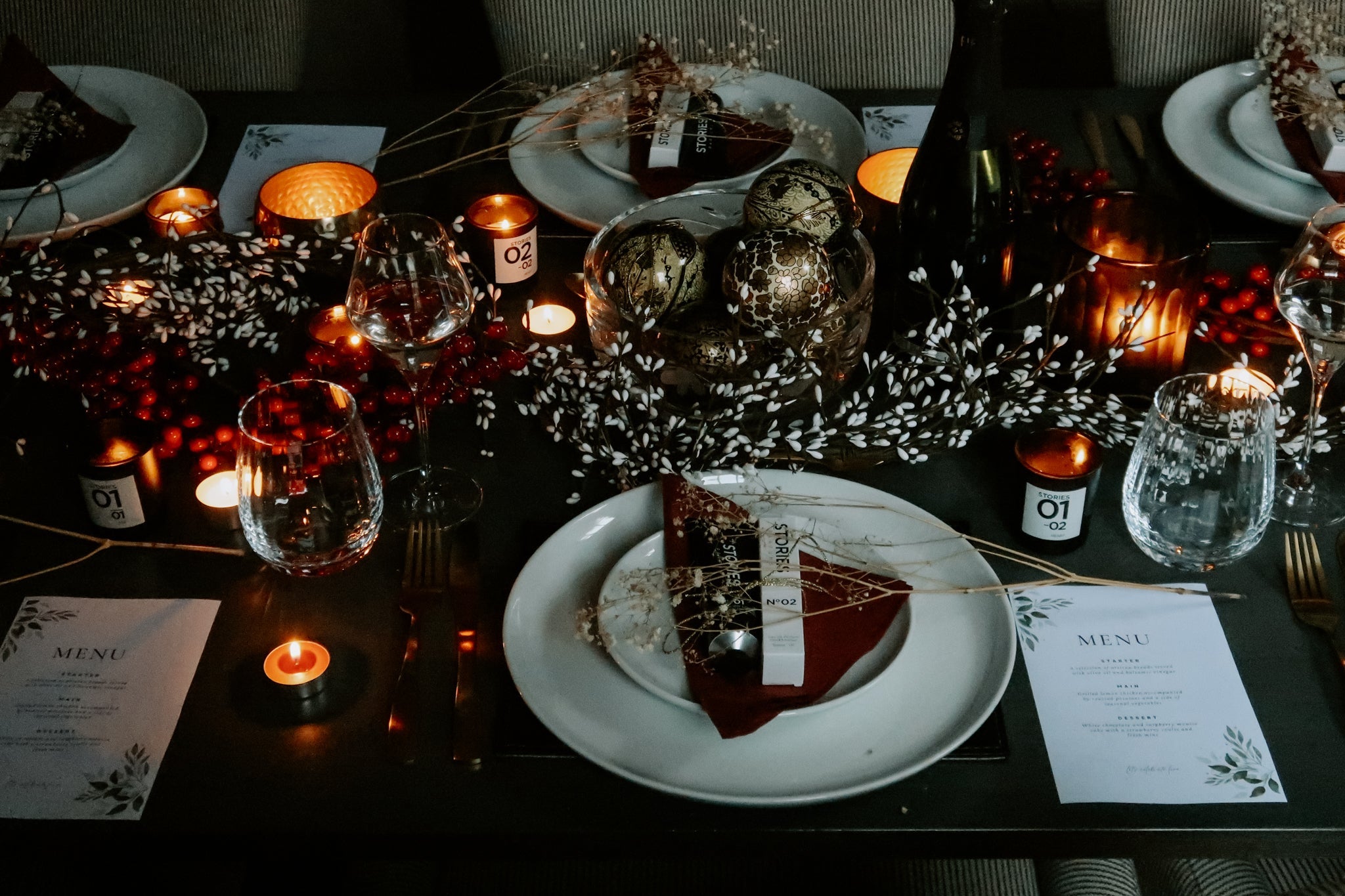 Christmas dinner table set with foliage, candles and glassware