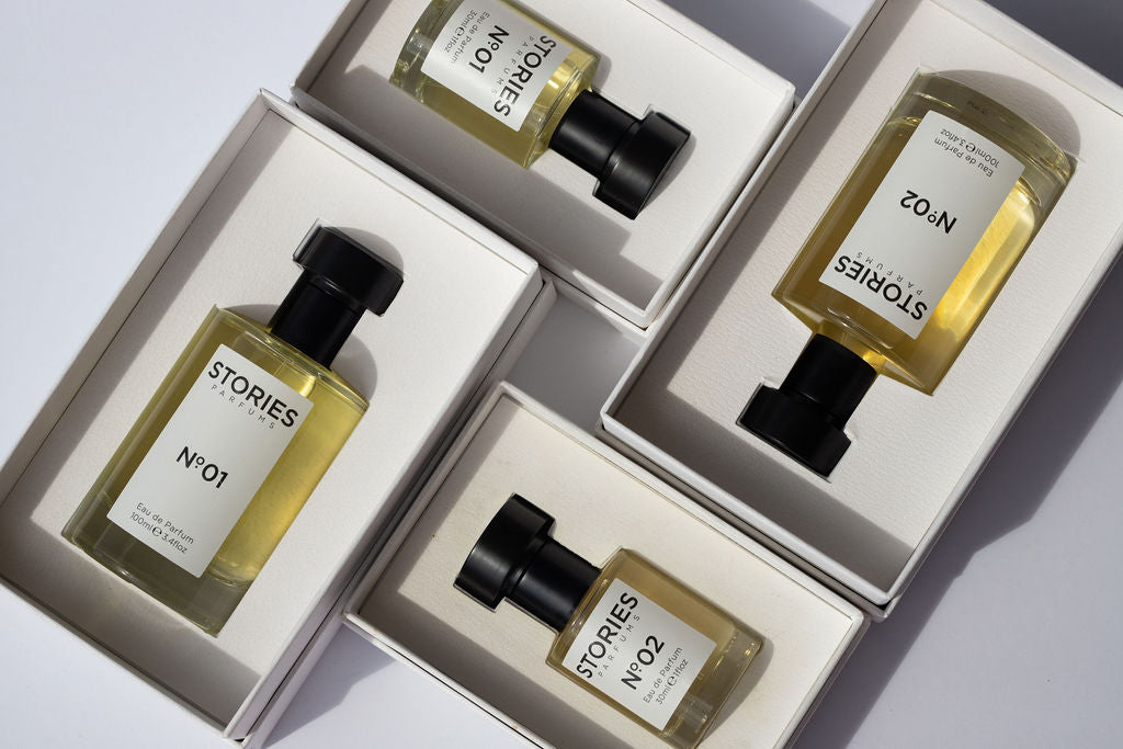 Bottles of STORIES perfume in white open boxes