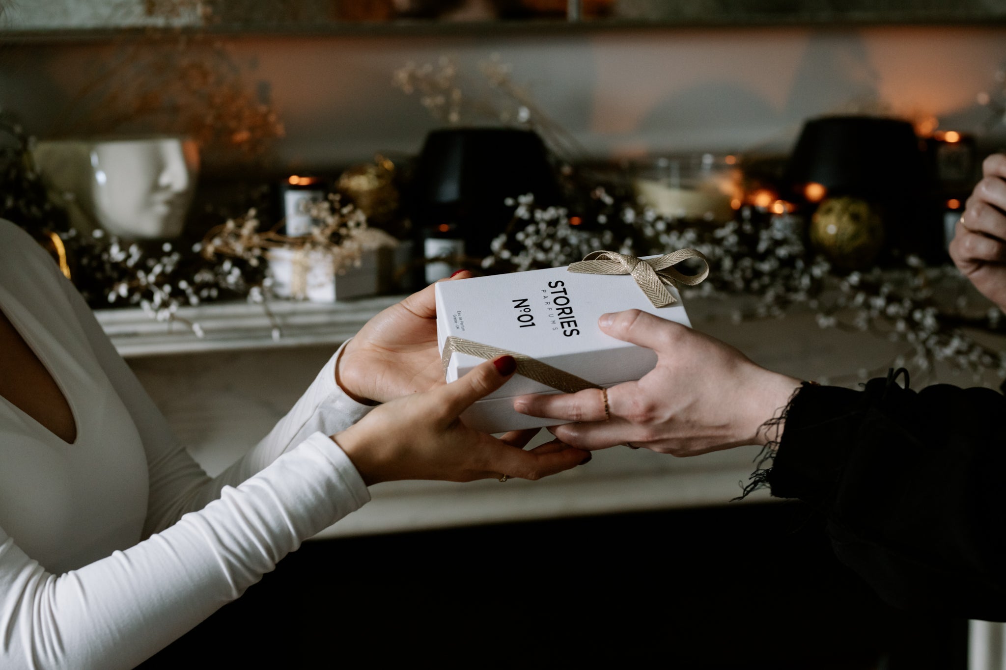 hands passing gift to oneanother by mantlepiece