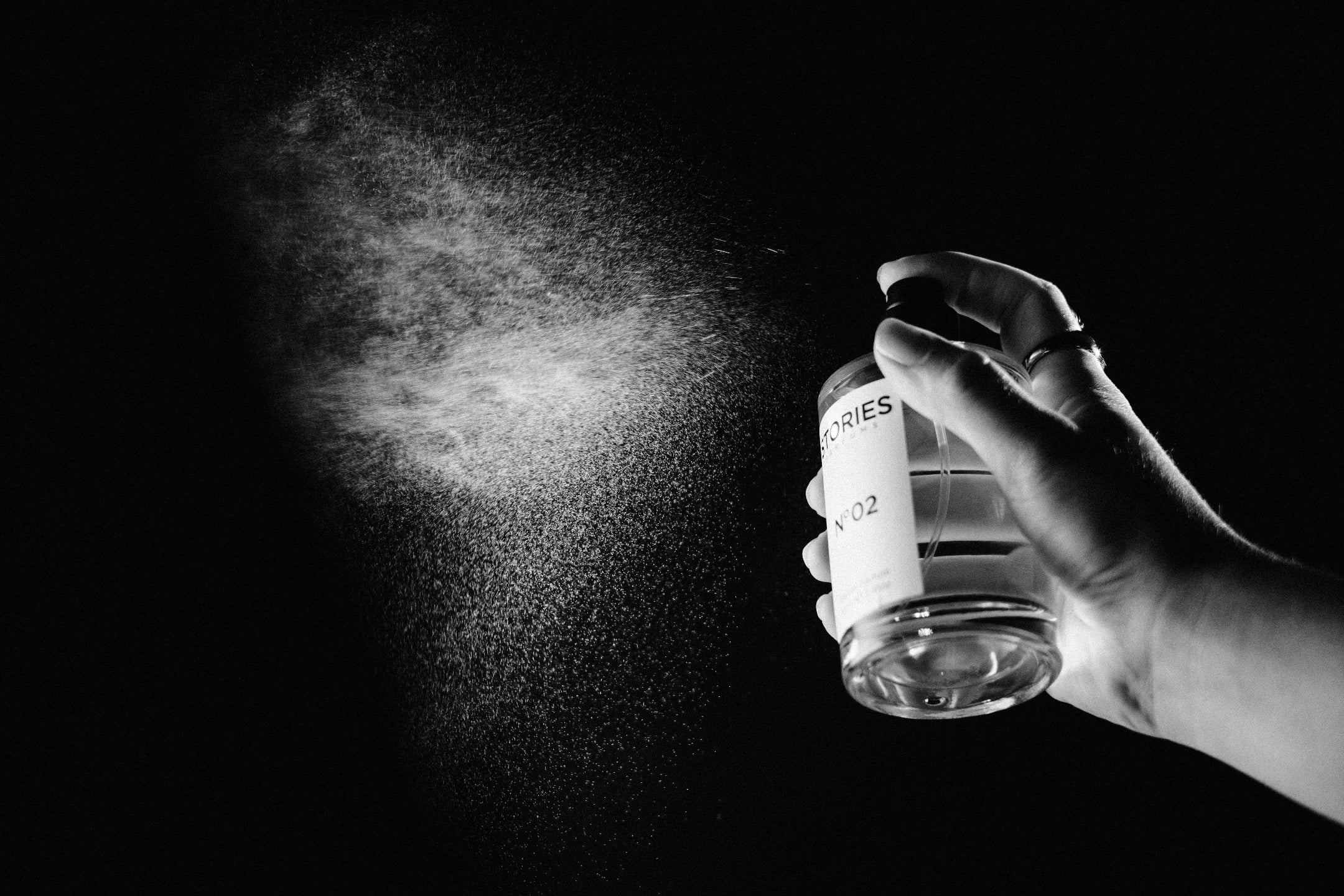 Hand spraying perfume into the air