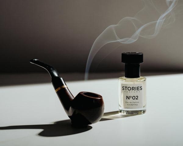 STORIES No.02 EDP bottle next to a smoking pipe with contrasting shadows