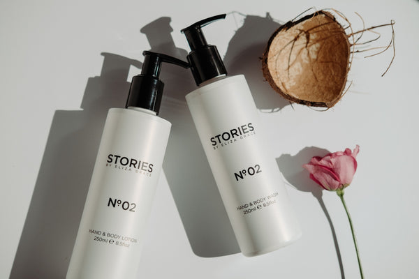 STORIES Hand and Body Lotion lying next to a flower and coconut shell