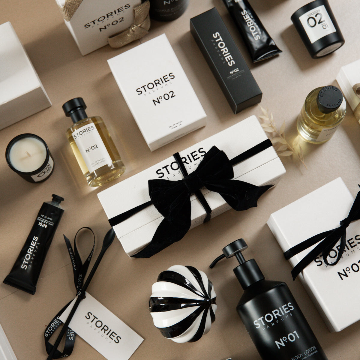 STORIES Nº.02 Christmas flat lay with Eau de Parfum, Hand & Body and gift boxes tied with black velvet ribbon
