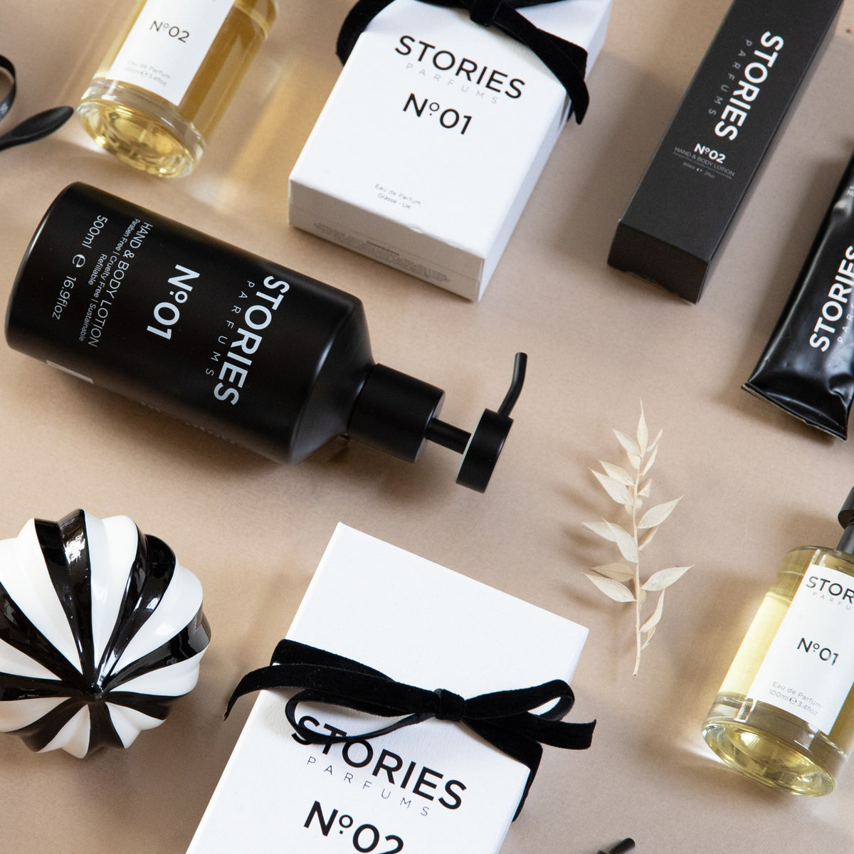 STORIES Nº.01 and STORIES Nº.02 Eau de Parfum boxes tied with black velvet ribbon, Christmas flat lay