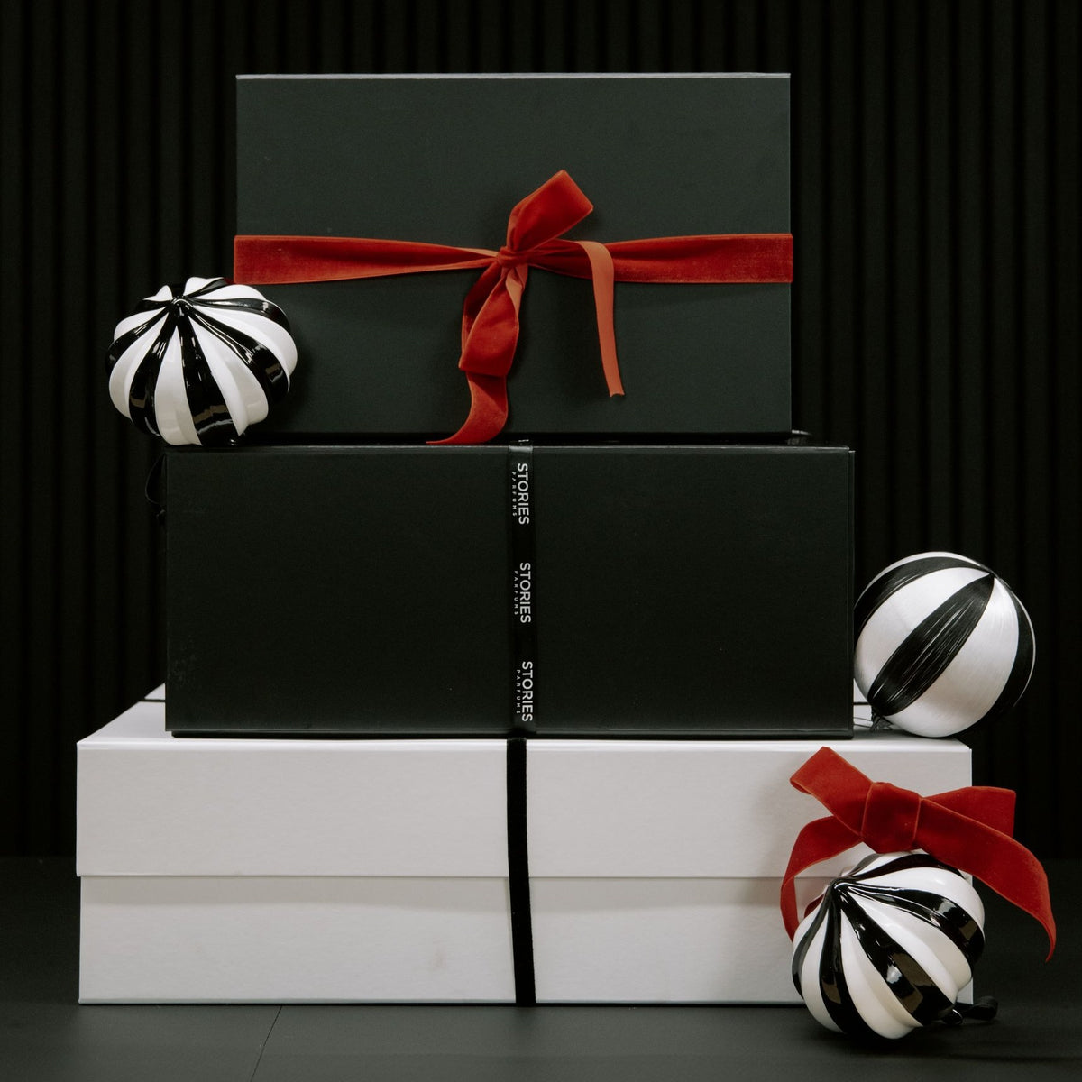 STORIES Christmas Gift Boxes stacked, black and white magnetic boxes tied with red velvet ribbon