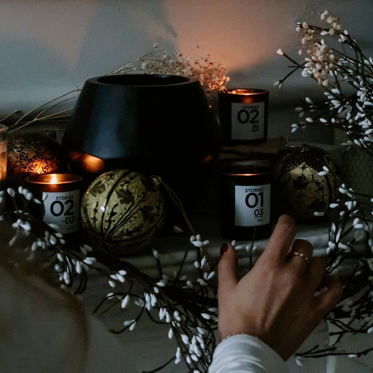 STORIES Bougie Parfumée candles lit on a Christmas mantel
